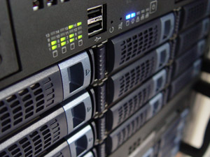 Close-up of rack-mounted servers with drive bays and status lights in a data center.